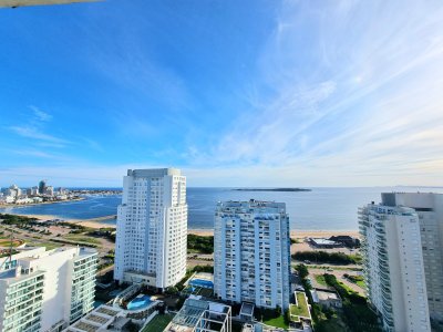Penthouse ubicado en uno de los puntos más destacados de Playa Mansa, Parada 5, con vista frontal al mar y orientación privilegiada para disfrutar de los mejores atardeceres de Punta del Este.

Se trata de una unidad semipiso con amplia terraza al frente, living comedor, cocina semi integrada, toilette social, y dos dormitorios en suite, (dormitorio secundario con terraza propia). Cada ambiente fue diseñado para ofrecer luminosidad, confort y funcionalidad.

El edificio ofrece servicios de alto nivel, entre los que se destacan:
servicio diario de mucamas, piscina exterior, canchas deportivas, sauna, gimnasio y seguridad.
La unidad incluye dos cocheras en garage con baulera.

Una opción ideal tanto para uso residencial como para renta en temporada, en un entorno consolidado y de gran demanda.

