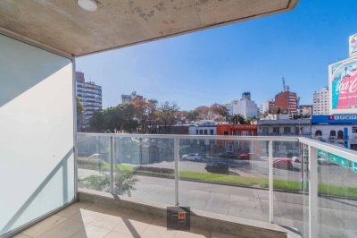 Edificio de viviendas de 1 y 2 dormitorios con patio verde.
