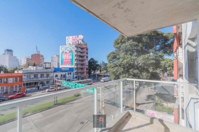 Edificio de viviendas de 1 y 2 dormitorios con patio verde.